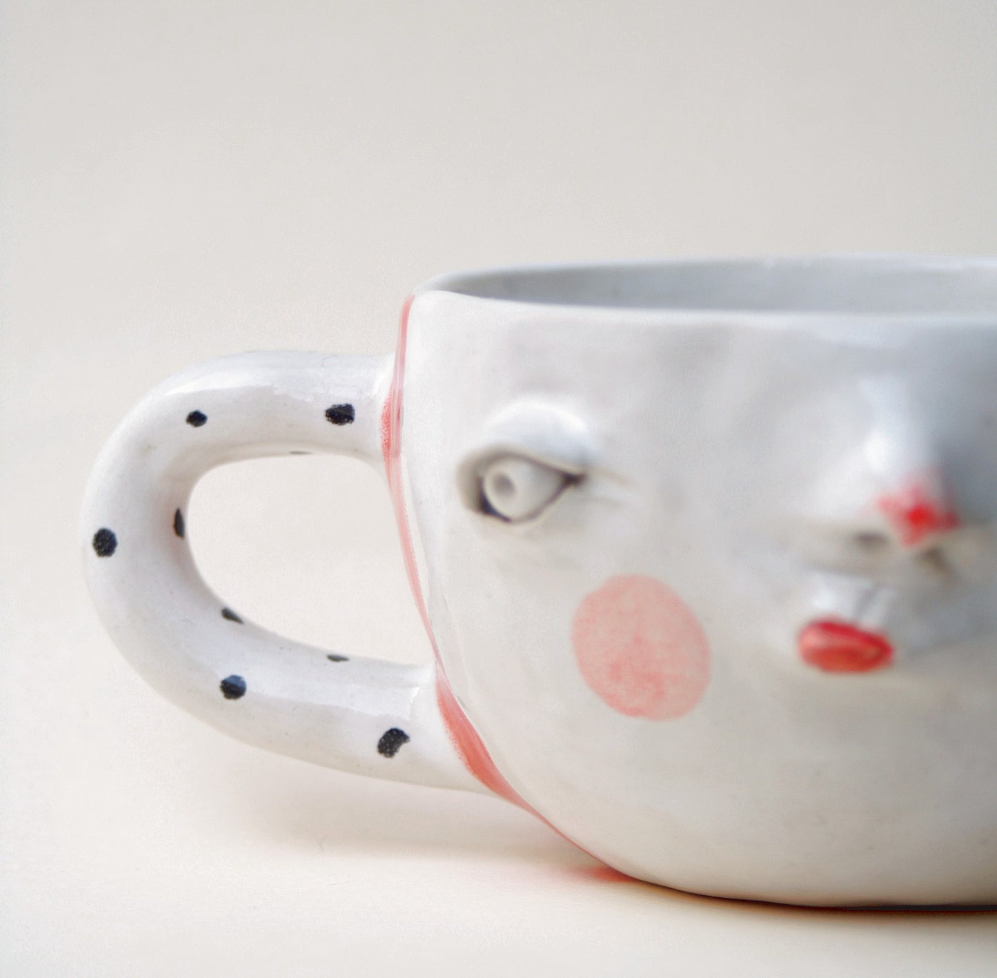 Kubek ceramiczny z twarzą w pasiastym wzorze