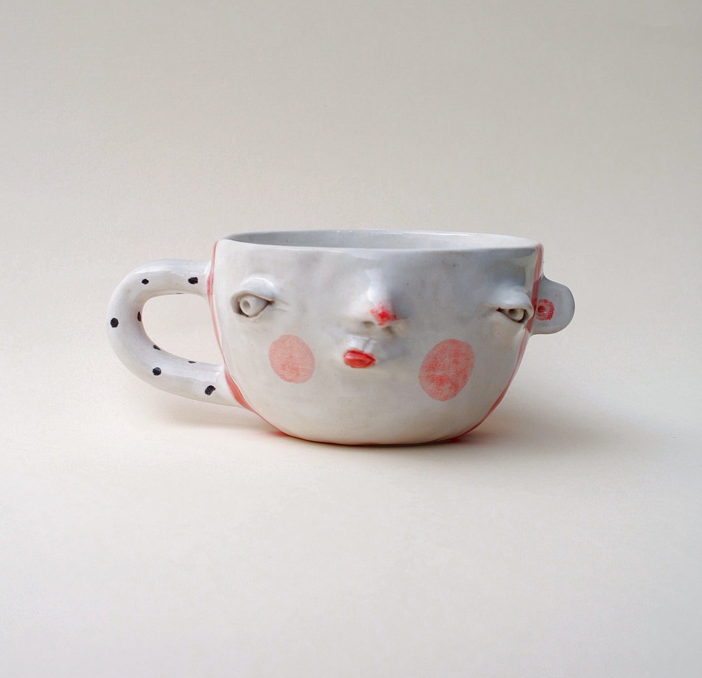 Kubek ceramiczny z twarzą w pasiastym wzorze