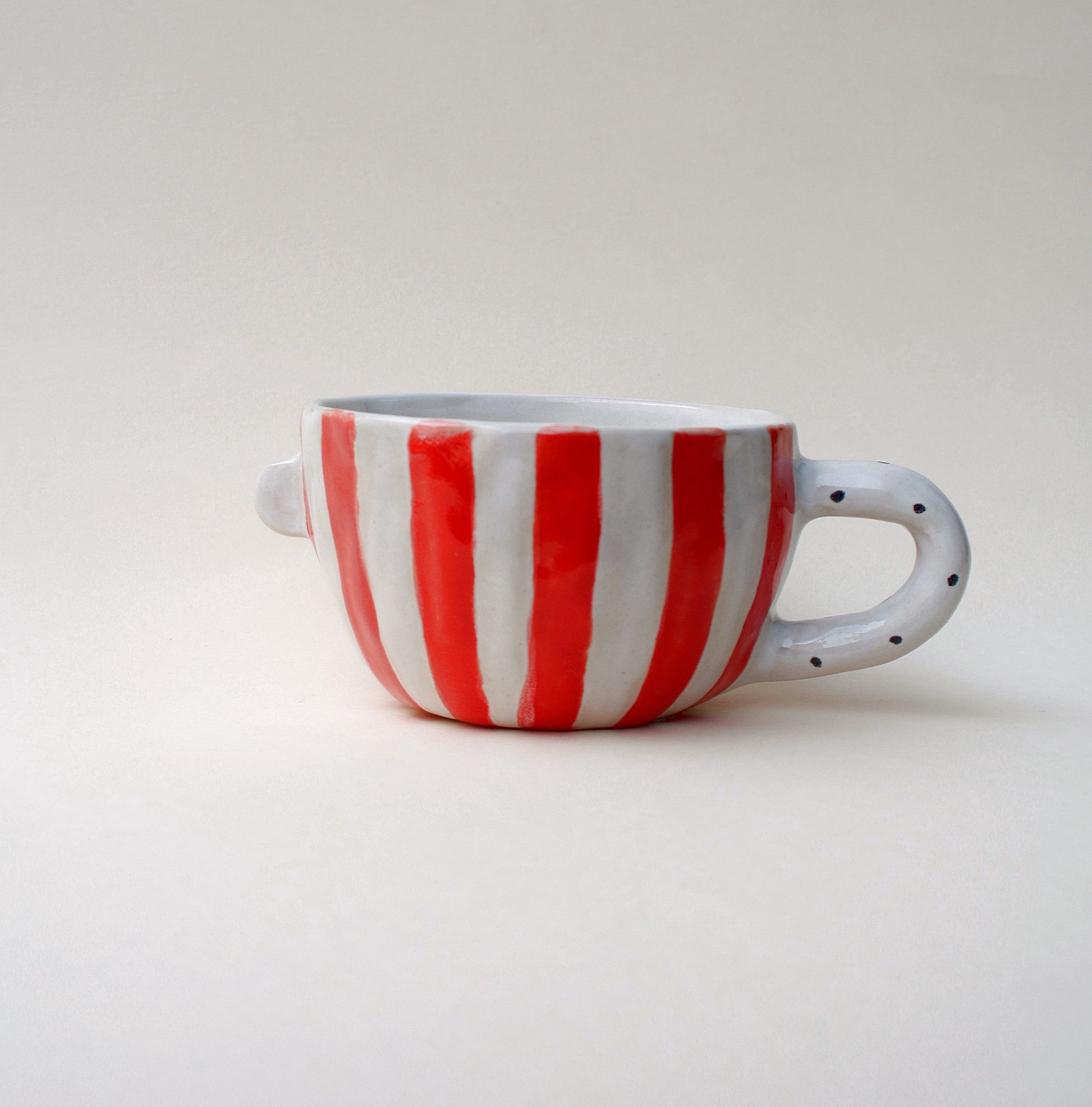 Kubek ceramiczny z twarzą w pasiastym wzorze