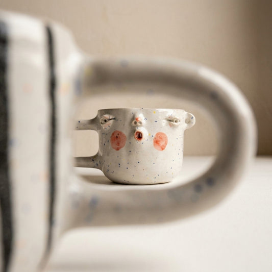 Ceramic mug with a face – white glaze, black handle and stripes