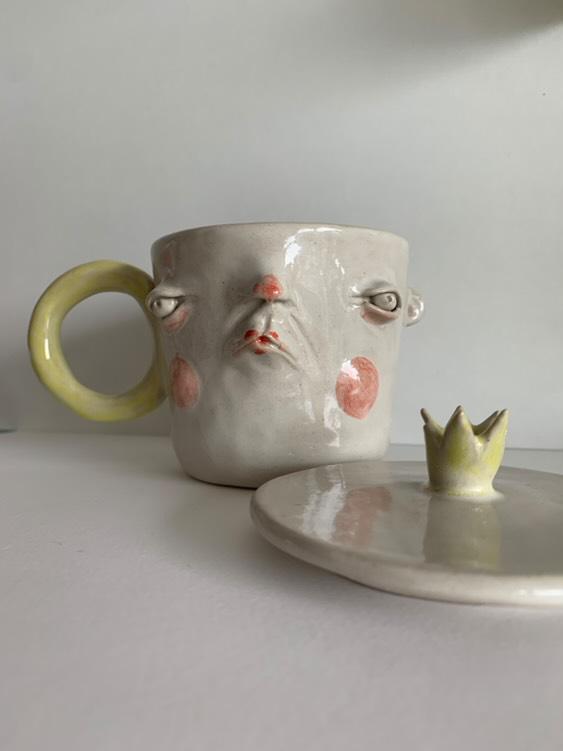 Kubek z twarzą w lekkim grymasie – ceramika z duszą