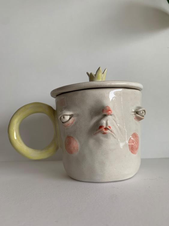 Kubek z twarzą w lekkim grymasie – ceramika z duszą